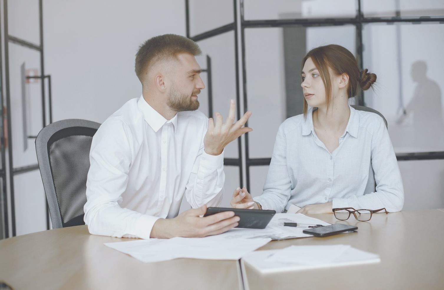 Person reviewing financial documents and planning materials spread across desk
